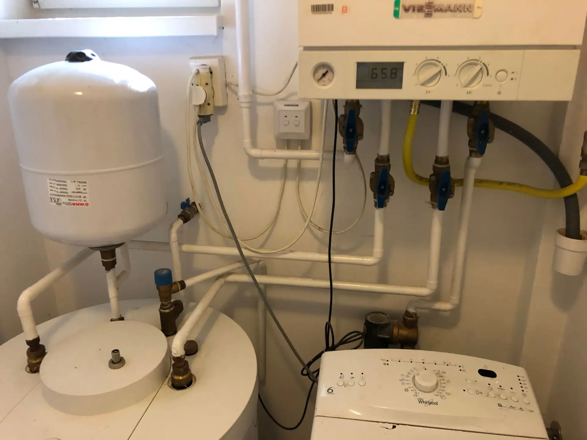 Viessmann fali kazán melegvíz-tárolóval és fali tágulási tartállyal egy szűk gépészeti sarokban